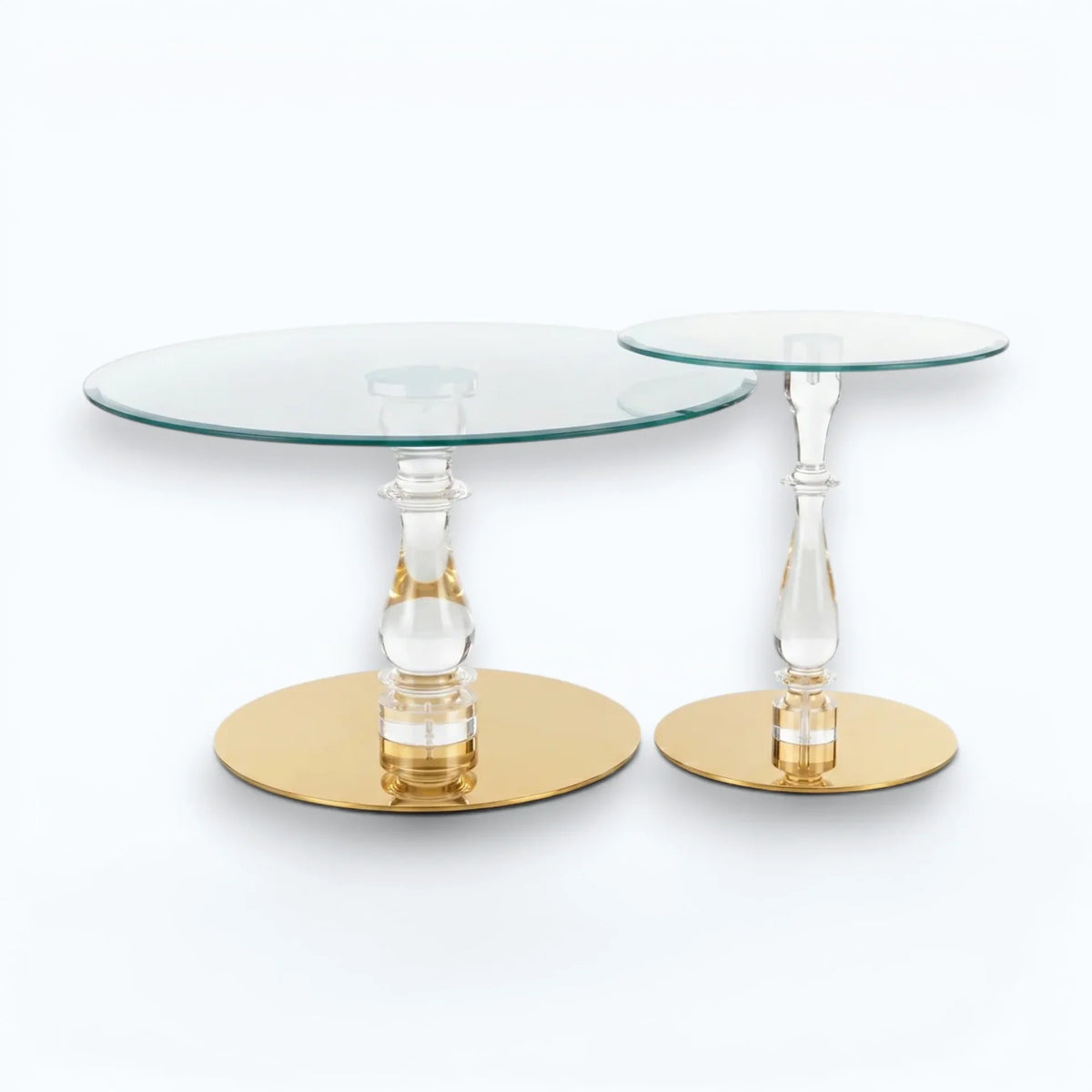 Set of two acrylic and tempered glass nesting coffee tables with crystal-clear pillars and high-shine gold bases