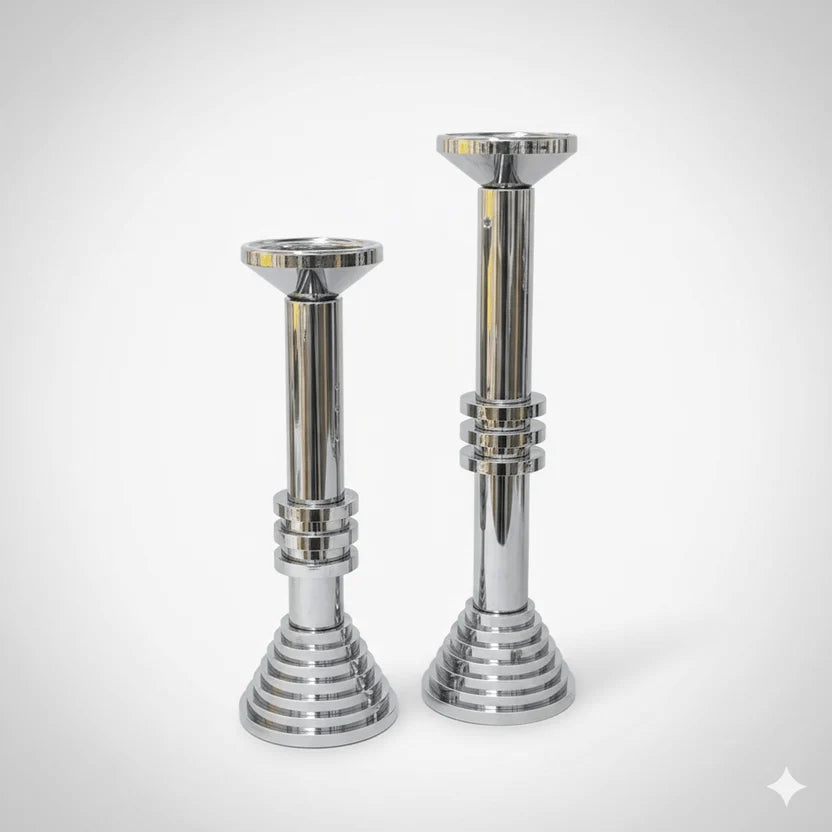 Two modern chrome sculptural candle holders on white background