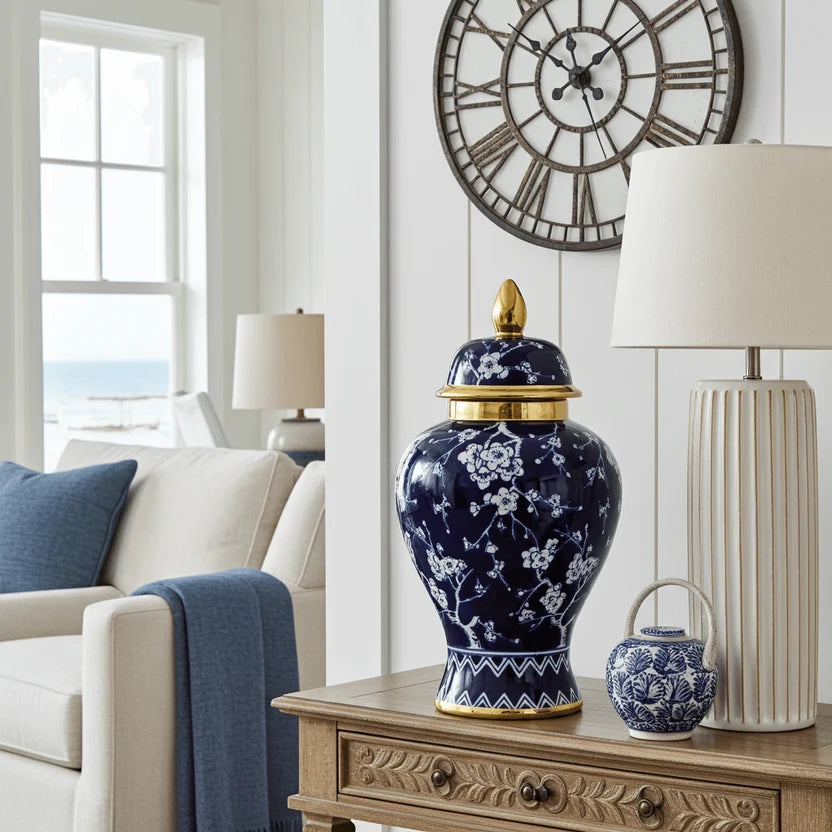 Navy ceramic jar with gold detailing on a wooden side table in a bright living room